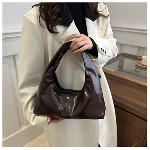 Détail du sac hobo café brillant montrant la texture cuir souple et le design minimaliste