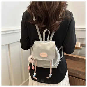 Back view of a mini light gray PU leather backpack with a pink plush doll and beads