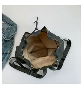 Detailansicht eines schwarzen Kordelzug-Rucksacks mit beigem Futter und Reißverschluss