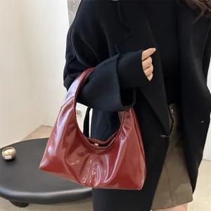 Sac hobo bordeaux en similicuir brillant avec une forme de croissant minimaliste