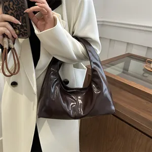 Sac hobo marron foncé en cuir verni brillant avec coutures vintage et plis