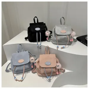 Mini velvet backpacks in black, grey, blue, and purple colors with cute plush pendants