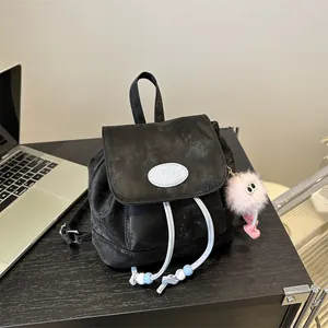 Mini black backpack with drawstring closure, brand logo and pink monster keychain