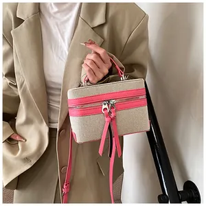 Detail van canvas boxtas met roze lederen biezen en dubbele rits voor damesmode