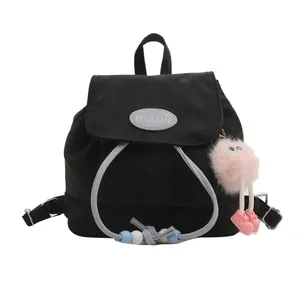 Fashionable black nylon backpack with light blue drawstring and pink plush monster charm