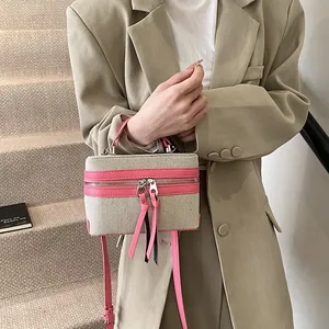 Vintage mini-boxtas van beige canvas en roze leer met lange kwastjes aan de ritssluitingen