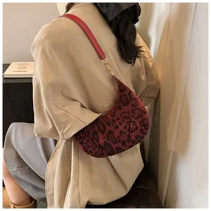 Detail of red and black leopard print hobo bag with textured fabric and red leather strap