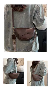 Close-up of vintage dark brown saddle bag with detailed stitching and dual shoulder straps