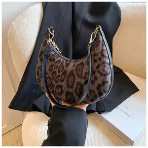 Detail of leopard print crescent bag with leather trim and gold zipper hardware