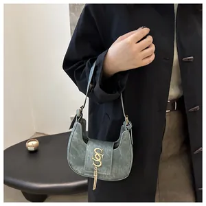 Vue détaillée du sac croissant avec logo SS doré et détails de franges métalliques
