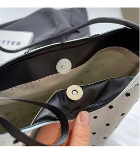 Détail du sac seau à pois blancs montrant le fermoir magnétique et doublure à chevrons