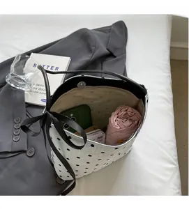Sac seau blanc à pois offrant un grand espace intérieur pour les articles essentiels
