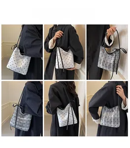 Détails du sac seau à pois avec cordon de serrage à nœud sur un modèle féminin