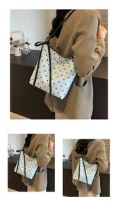 Détail du sac cabas en tweed bleu clair à pois avec un nœud en soie noire et de fines lanières