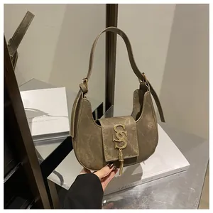 Détail du logo doré sur un sac sous le bras vintage kaki foncé au fini mat