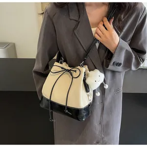 Detail of canvas bucket bag with contrast leather bottom and plush cloud charm