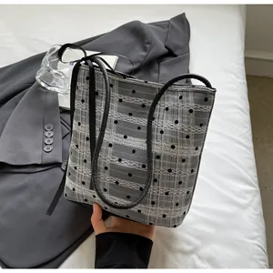 Détail d'un sac cabas à pois noir et blanc avec dentelle et ruban noir décoratif
