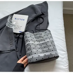 Détail du sac seau à carreaux avec pois noirs et décoration de nœud en ruban de soie