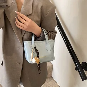 Fashionable light blue glossy mini tote bag with baseball charms and gold text