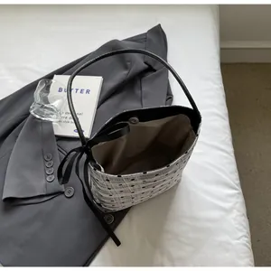 Détail du sac cabas à carreaux argentés avec pois noirs et fermeture à nœud décoratif