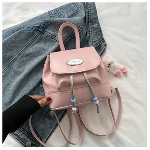 Detail of pink faux leather mini backpack with drawstring and plush monster charm