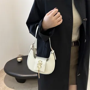 Sac demi-lune minimaliste crème avec logo S doré et détail de longues franges en cuir