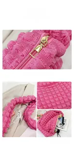 Detail of hot pink bubble textured handbag featuring a premium gold zipper and spacious interior