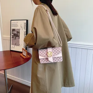 Pink and beige crossbody bag with letter print and golden buckle on model