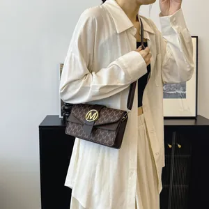 Brown monogram PU leather crossbody bag with golden M buckle and adjustable strap