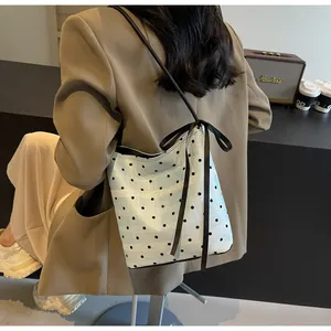Détail du sac seau bleu clair à pois avec ruban noir élégant et bandoulière fine