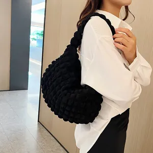 Detail of black cloud shoulder bag with textured bubble fabric and crescent shape design