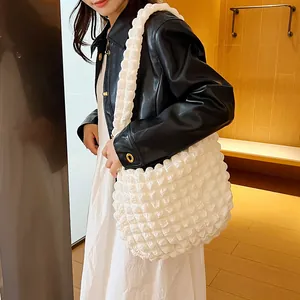 Detail of white puff tote bag featuring unique popcorn textured fabric and soft wide strap