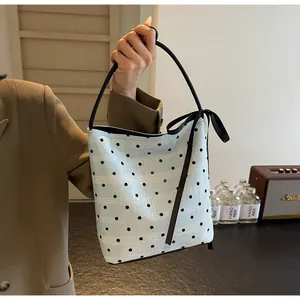 Détail du sac seau bleu clair à pois avec nœud noir et texture de motif de dentelle chic