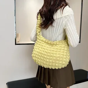 Detailed view of pale yellow puffer tote bag featuring soft textured bubble fabric