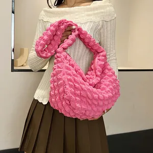 Macro detail of bright pink pleated hobo bag showing high-elasticity bubble texture and zipper