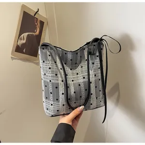 Détail du sac cabas en maille avec pois noirs et nœud décoratif pour femme élégante