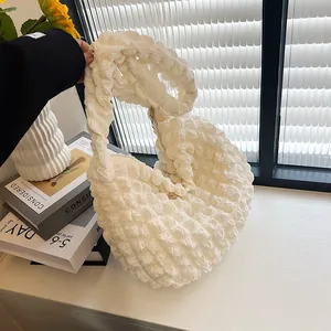 Detail of white popcorn fabric texture and soft pleated design on this shoulder bag