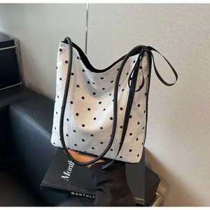 Détail du sac à bandoulière blanc à pois noirs avec bandoulière et ruban élégant