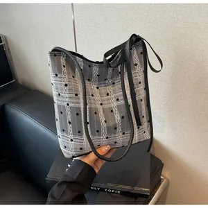 Détail du motif dentelle blanche et maille à pois noirs sur le sac cabas chic