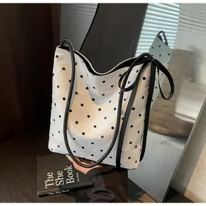 Sac fourre-tout blanc à pois noirs avec nœud latéral et bandoulière élégante