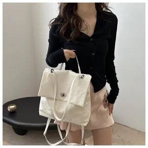 Detail of off-white pleated backpack with silver twist lock and minimalist design