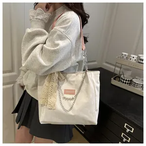 Detailed shot of white tote bag featuring pink accents, pearls, and lace on model