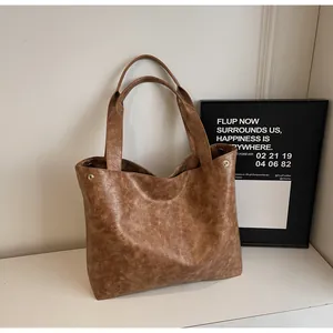 Detail view of large brown vintage tote bag with retro marble texture and golden rivets