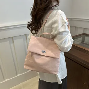 Pink textured backpack with silver twist lock shown on model for casual style