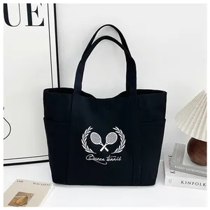 Detail of the black canvas tote bag showing side pockets and white tennis pattern print