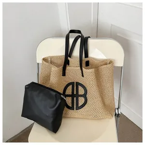 Détail du sac cabas en paille tissée avec anses en cuir noir et pochette interne