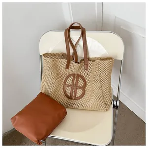 Détail du grand sac cabas en paille tressée avec anses en cuir marron et pochette interne