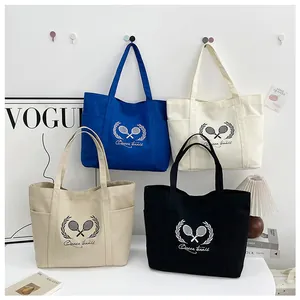 Detail of multi-color canvas tote bags with Queen tennis print and side pockets