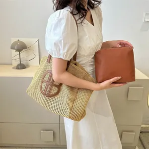 Sac fourre-tout chic en paille avec lanières marron contrastées porté par un mannequin