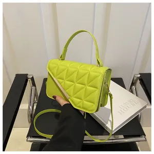 Detail of neon green quilted handbag showing diamond pattern and metal side buckle